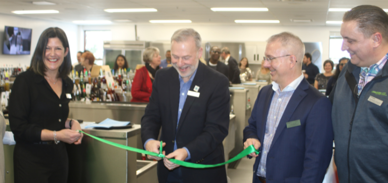 A photo of College President Claude Brulé - and others - officially cutting a ribbon to open the newly renovated bar lab.