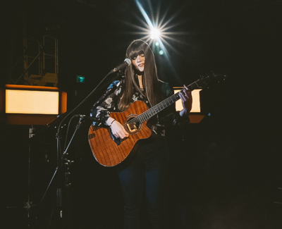 Danielle performing with guitar