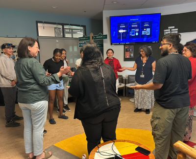 Presenters display a hand slapping game with attendees of their Northern Youth Abroad talk