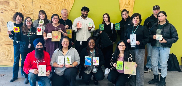 group poses with cedar art